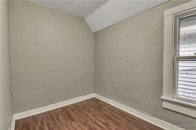 unfurnished room with lofted ceiling, plenty of natural light, and dark hardwood / wood-style flooring