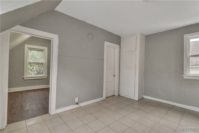 unfurnished bedroom featuring light wood-type flooring and vaulted ceiling