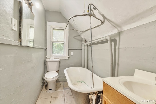 bathroom with vanity, lofted ceiling, toilet, a tub, and tile patterned floors