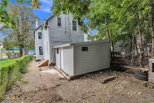 rear view of property featuring a storage shed