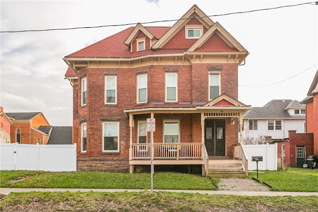 view of front of property with covered porch and a front yard