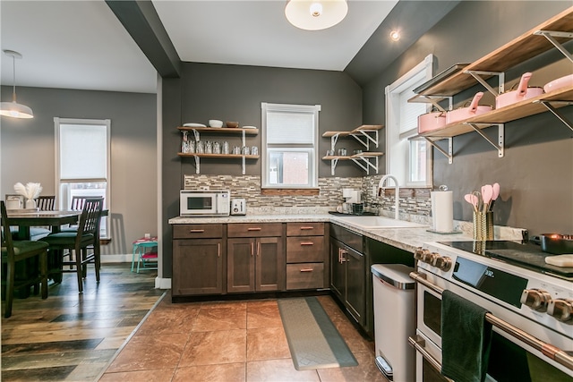 kitchen featuring hanging light fixtures, light hardwood / wood-style floors, a healthy amount of sunlight, and high end range