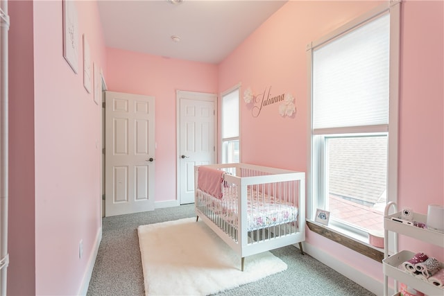 bedroom featuring a crib and carpet floors