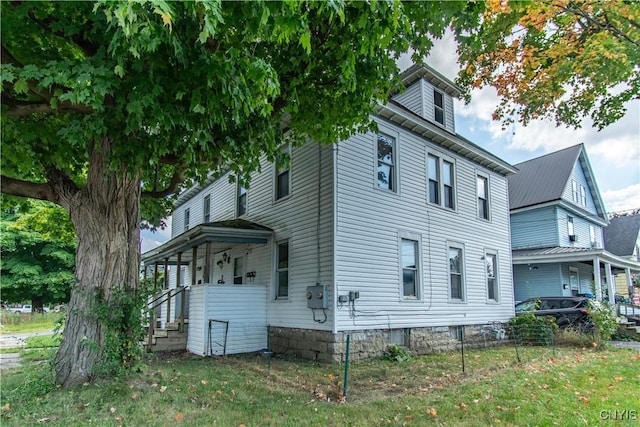 view of side of home featuring a lawn and a balcony