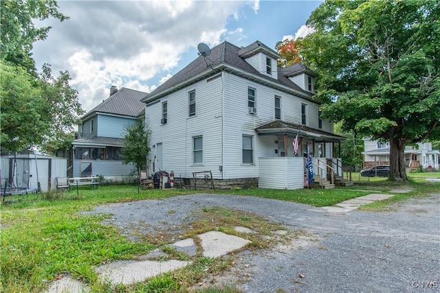rear view of property featuring a chimney and an outbuilding