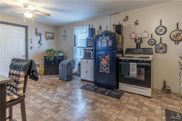 kitchen with black refrigerator, ceiling fan, and gas range gas stove