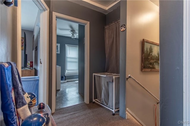 hallway featuring baseboards, an upstairs landing, carpet floors, and washer / clothes dryer