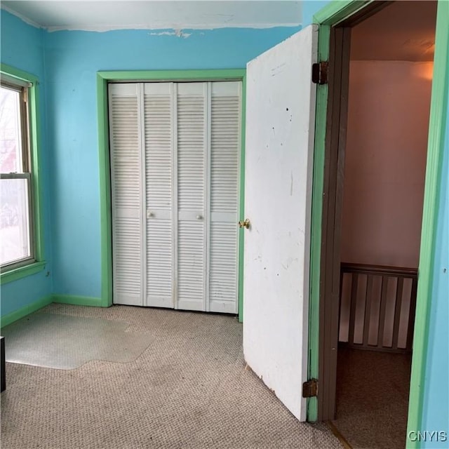 unfurnished bedroom featuring light carpet and a closet