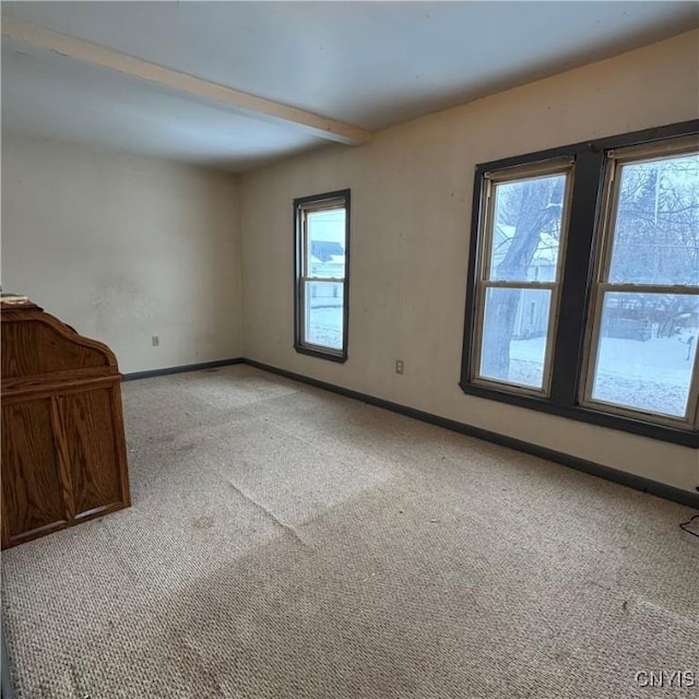 unfurnished living room featuring light colored carpet and beam ceiling