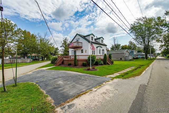 view of front of home featuring a wooden deck and a front lawn