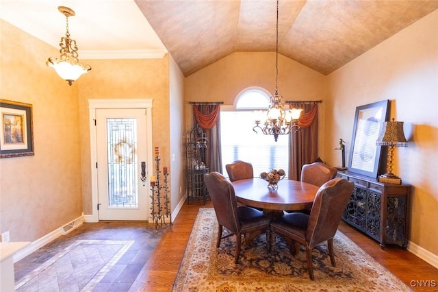 dining area with a chandelier, wood-type flooring, plenty of natural light, and lofted ceiling