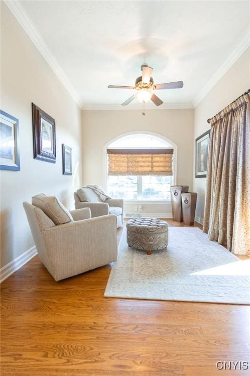 living room with ceiling fan, crown molding, and light hardwood / wood-style flooring