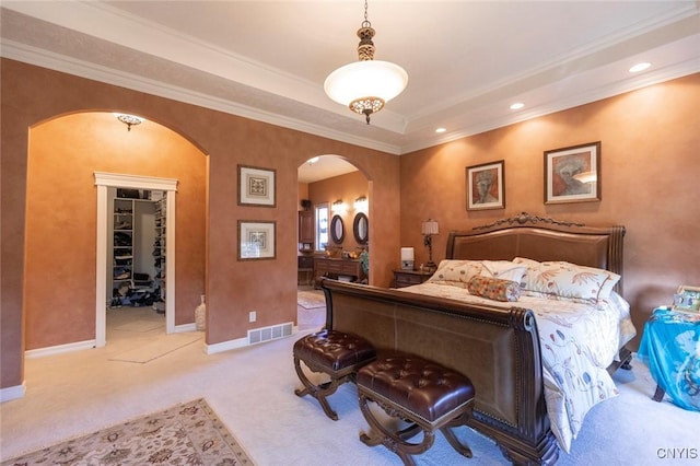 bedroom featuring light carpet, a spacious closet, a closet, and ornamental molding