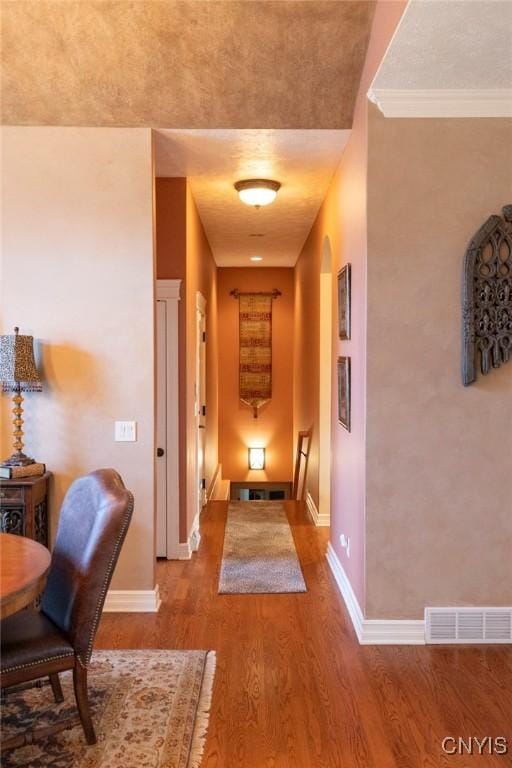 hallway with crown molding and hardwood / wood-style floors