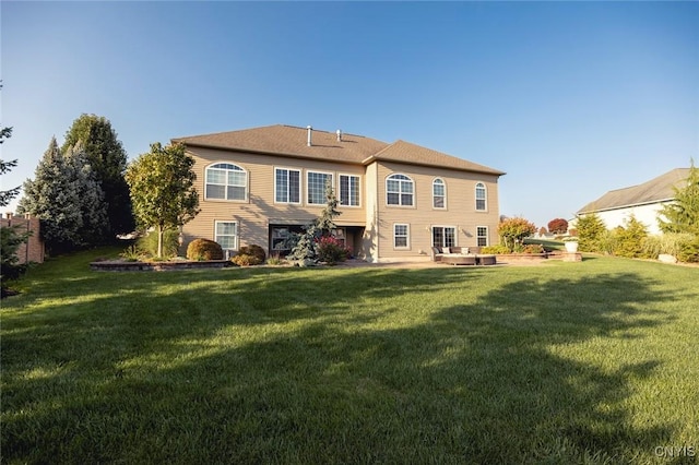 back of property with a lawn and a patio area