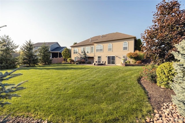 rear view of property featuring a lawn