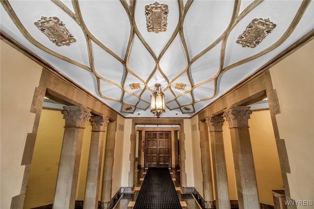 hall featuring decorative columns and ornamental molding