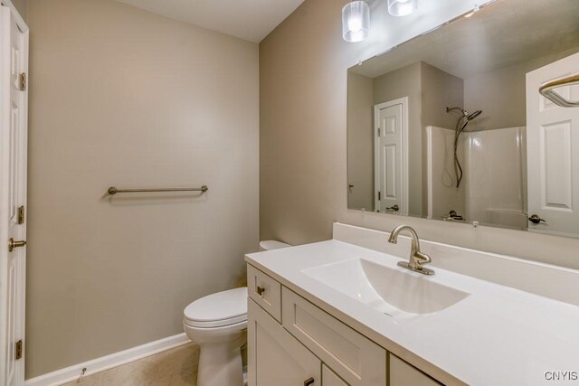 bathroom featuring walk in shower, vanity, and toilet