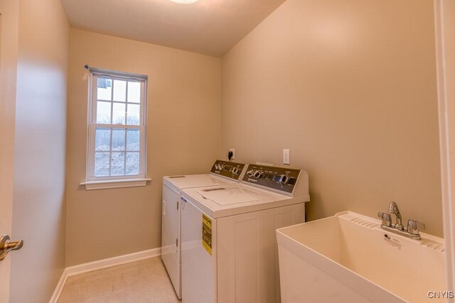 clothes washing area with light carpet, sink, and washer and dryer