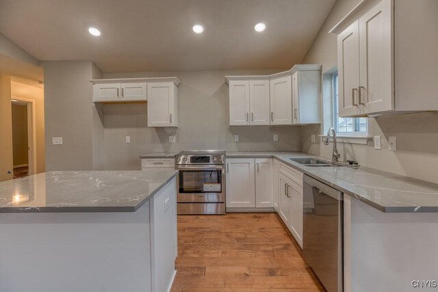 kitchen featuring appliances with stainless steel finishes, white cabinetry, sink, and light hardwood / wood-style flooring