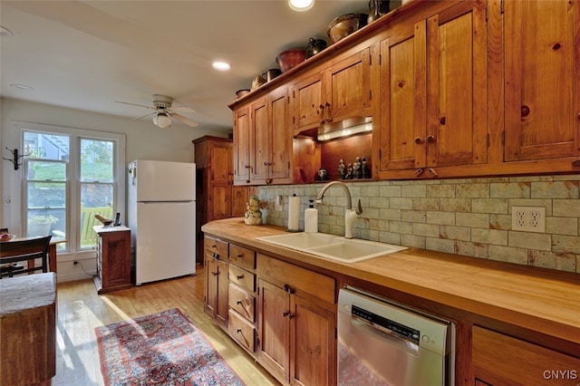 kitchen with white fridge, light wood-type flooring, ceiling fan, stainless steel dishwasher, and sink