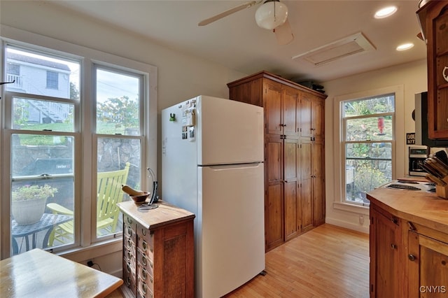 kitchen with light hardwood / wood-style flooring, a wealth of natural light, and white refrigerator