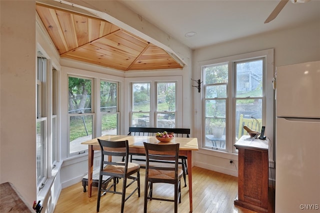 dining room featuring wood ceiling, lofted ceiling, light hardwood / wood-style floors, and ceiling fan