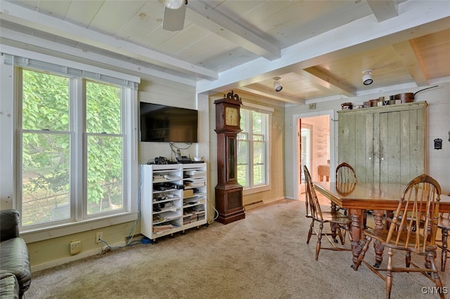 dining space with a healthy amount of sunlight, carpet, and beam ceiling