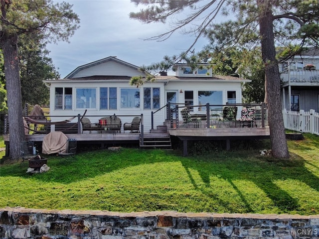 rear view of house featuring a deck and a yard