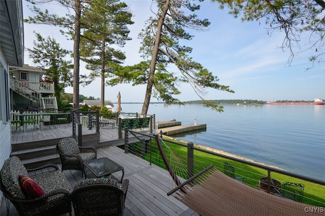 wooden deck featuring a lawn and a water view