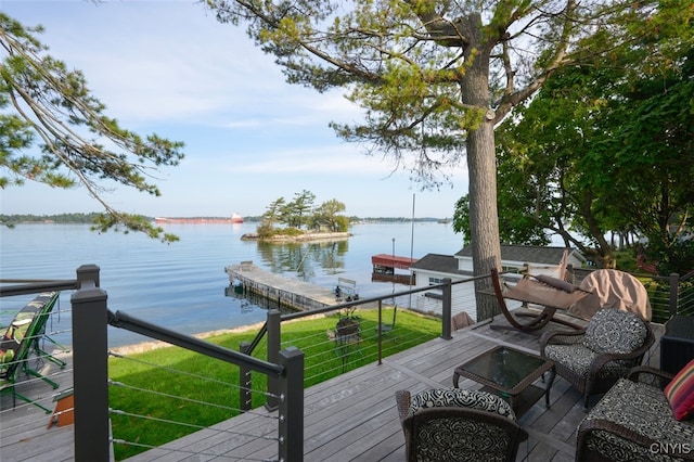 deck with a dock, a yard, and a water view