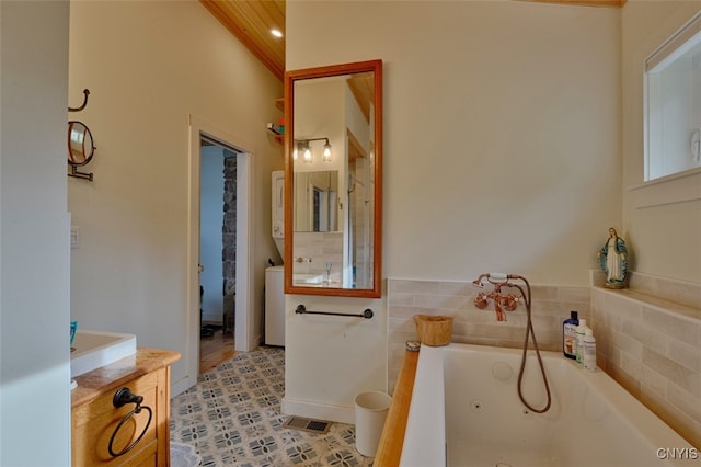 bathroom with tile patterned flooring, vanity, and a bathing tub