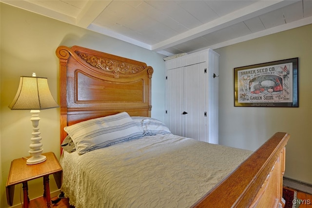 bedroom featuring wood-type flooring and beam ceiling