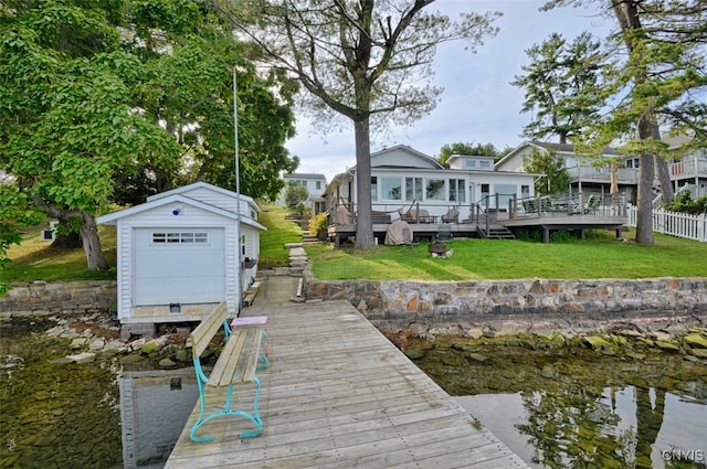 dock area featuring a lawn and a deck with water view