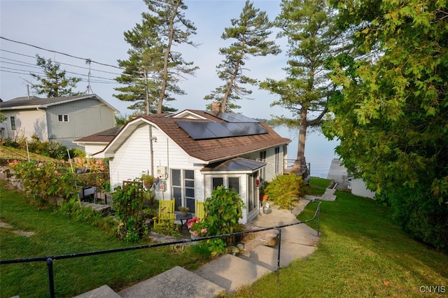 view of side of home featuring solar panels and a lawn