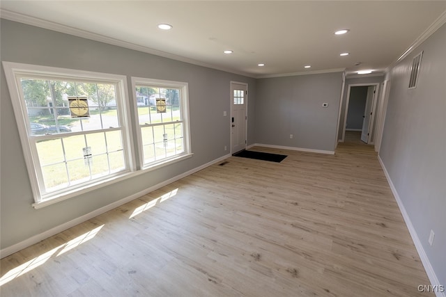 foyer entrance with crown molding and light hardwood / wood-style floors