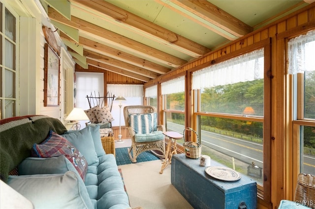 sunroom featuring a wealth of natural light and vaulted ceiling with beams