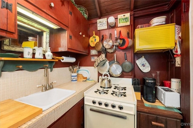 3544 State Route 28, Webb, NY 13420 - kitchen with white gas range oven, a sink, tasteful backsplash, wooden ceiling, and open shelves