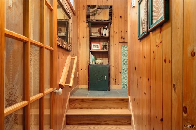 staircase featuring wooden walls