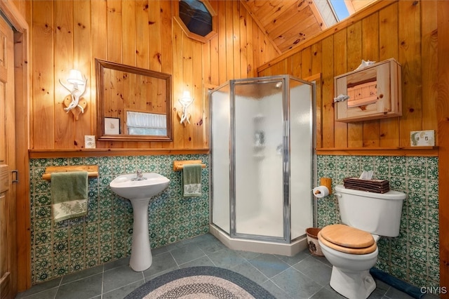 bathroom with vaulted ceiling with skylight, tile patterned flooring, toilet, and an enclosed shower