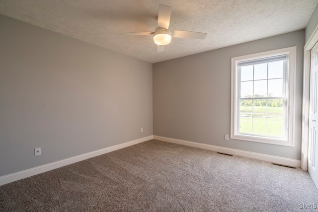 spare room with carpet, ceiling fan, and a textured ceiling