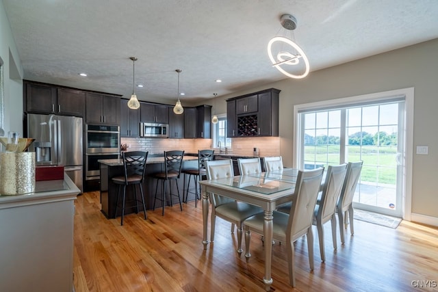 dining area featuring light hardwood / wood-style flooring, a textured ceiling, and sink