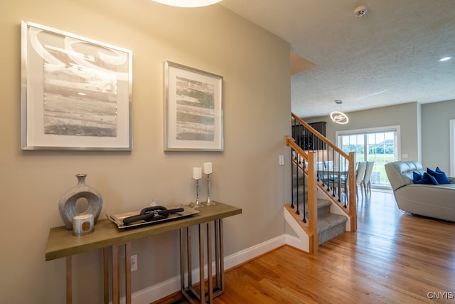 hall featuring a textured ceiling and hardwood / wood-style floors