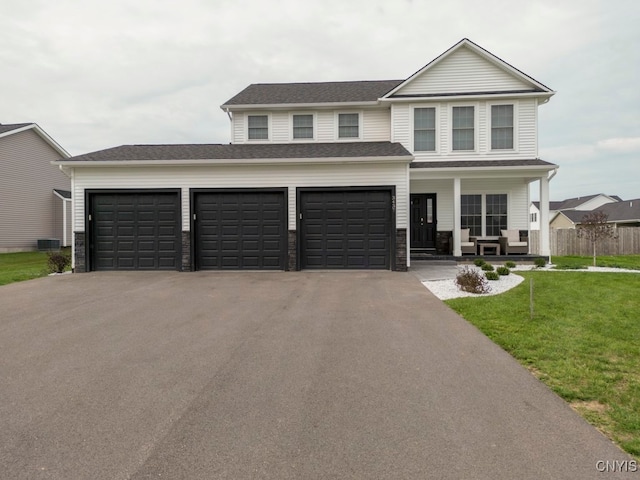 front of property featuring a front yard, a porch, and a garage