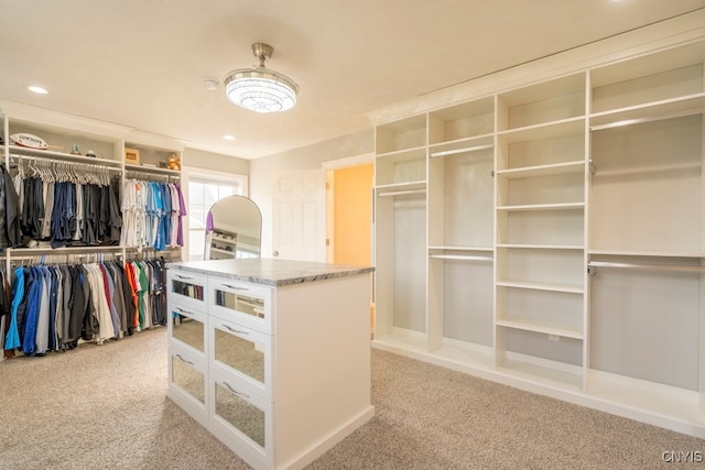 spacious closet featuring light colored carpet