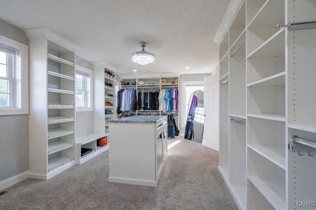 walk in closet featuring light carpet