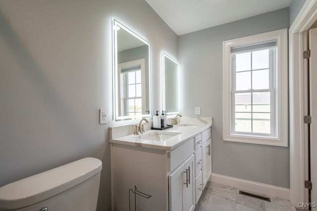 bathroom with plenty of natural light, vanity, and toilet