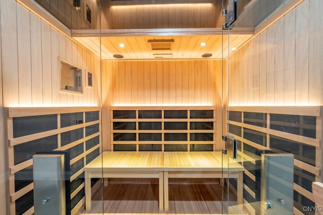 view of sauna featuring wood ceiling and wood walls