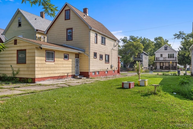 back of property featuring a lawn