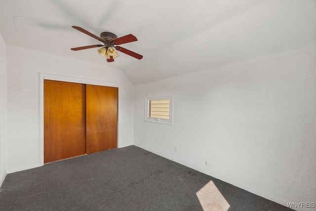 unfurnished bedroom with carpet flooring, ceiling fan, lofted ceiling, and a closet